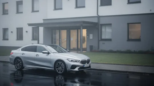 Voiture récente garée près d’un bâtiment institutionnel, suggérant une démarche d’immatriculation maîtrisée et sans blocage.